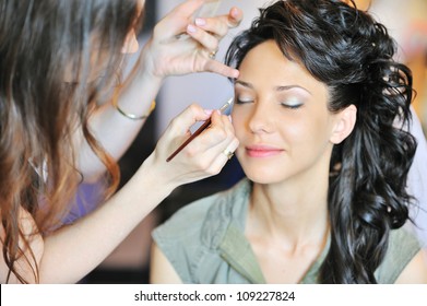 Young beautiful bride applying wedding make-up by make-up artist - Powered by Shutterstock