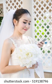 Young beautiful bride using mobile phone