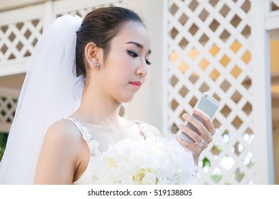 Young beautiful bride using mobile phone