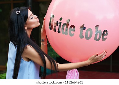 Young Beautiful Brunette Bride To Be With Black Hair And Silver Crown On It Kissing Her Pink Bachelorette Party Balloon