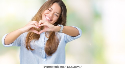 Young beautiful brunette business woman over isolated background smiling in love showing heart symbol and shape with hands. Romantic concept. - Shutterstock ID 1305983977