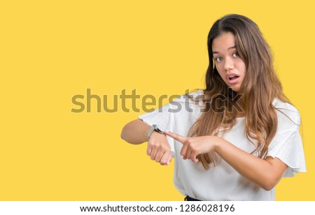 Young beautiful brunette business woman over isolated background In hurry pointing to watch time, impatience, upset and angry for deadline delay