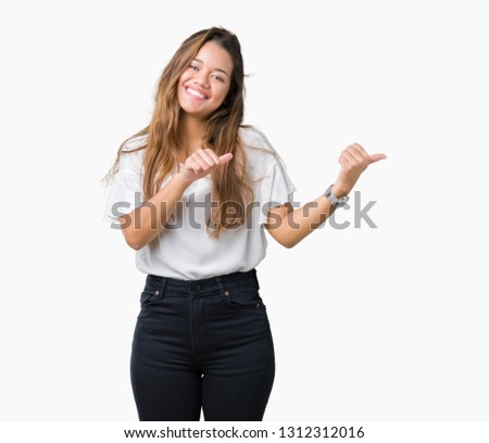 Young beautiful brunette business woman over isolated background Pointing to the back behind with hand and thumbs up, smiling confident