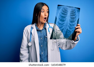 Young Beautiful Brunette Doctor Woman Wearing Stethoscope Holding Chest Xray Scared In Shock With A Surprise Face, Afraid And Excited With Fear Expression