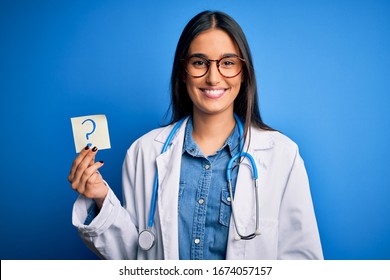 Young Beautiful Brunette Doctor Woman Holding Paper With Question Mark Symbol Message With A Happy Face Standing And Smiling With A Confident Smile Showing Teeth