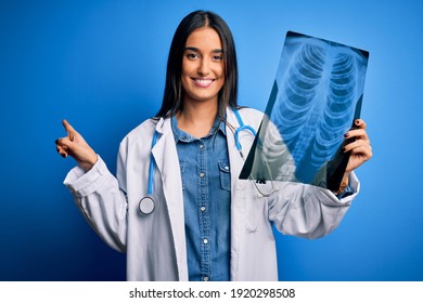 Young Beautiful Brunette Doctor Woman Wearing Stethoscope Holding Chest Xray Very Happy Pointing With Hand And Finger To The Side