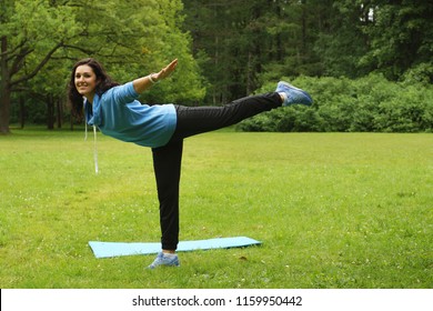 Young Beautiful Brunette Doing Swallow Exercise In Summer Morning Park