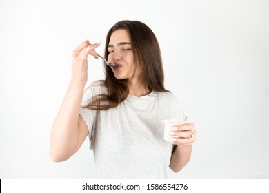 Young Beautiful Brunette Woman Eating Yogurt With Spoon Looking Satisfied Healthy Lifestyle Isolated White Background