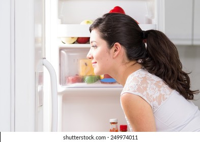 Young Beautiful Brunette Woman Searching For Food In The Fridge