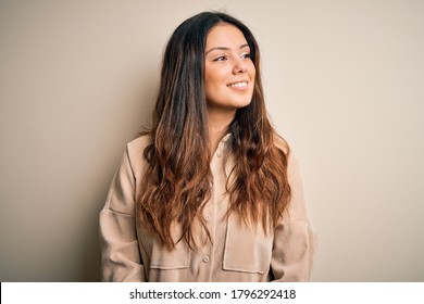 Young Beautiful Brunette Woman Wearing Casual Shirt Standing Over White Background Looking Away To Side With Smile On Face, Natural Expression. Laughing Confident.