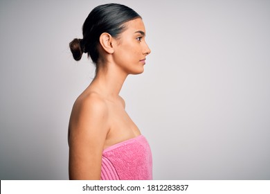 Young Beautiful Brunette Woman Wearing Towel After Shower Over Isolated White Background Looking To Side, Relax Profile Pose With Natural Face With Confident Smile.