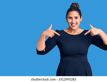 Young beautiful brunette woman wearing casual dress looking confident with smile on face, pointing oneself with fingers proud and happy. 