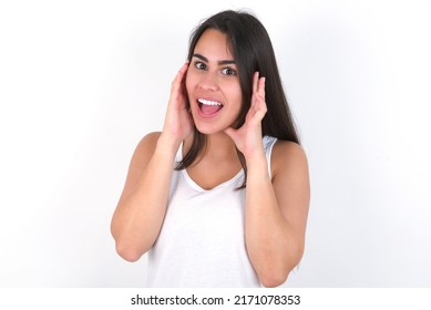 Young Beautiful Brunette Woman Wearing White Top Over White Wall Pleasant Looking Cheerful, Happy Reaction