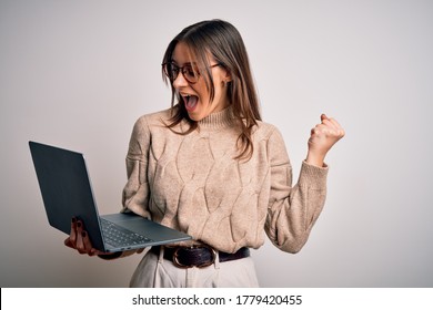 Young beautiful brunette woman working using laptop over isolated white background screaming proud and celebrating victory and success very excited, cheering emotion - Shutterstock ID 1779420455