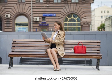 Young Beautiful Business Woman Sitting On A Bench In The Summer City