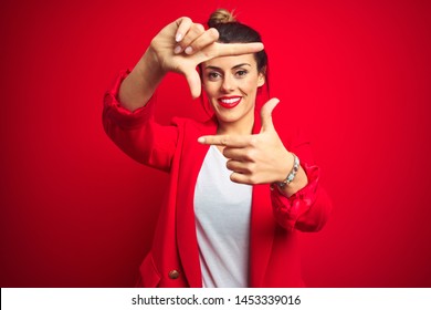 Young beautiful business woman standing over red isolated background smiling making frame with hands and fingers with happy face. Creativity and photography concept. - Powered by Shutterstock