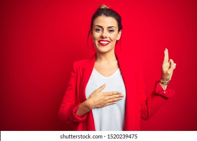 Young Beautiful Business Woman Standing Over Red Isolated Background Smiling Swearing With Hand On Chest And Fingers Up, Making A Loyalty Promise Oath