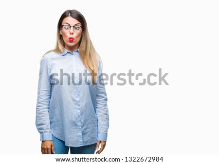 Young beautiful business woman wearing glasses over isolated background making fish face with lips, crazy and comical gesture. Funny expression.