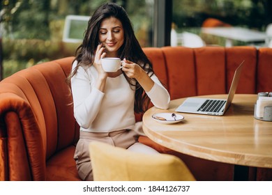 Young beautiful business woman working on cimputer in a cafe