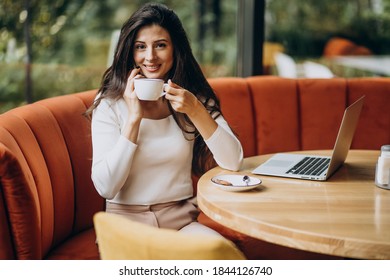 Young beautiful business woman working on cimputer in a cafe