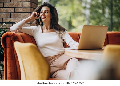 Young beautiful business woman working on cimputer in a cafe