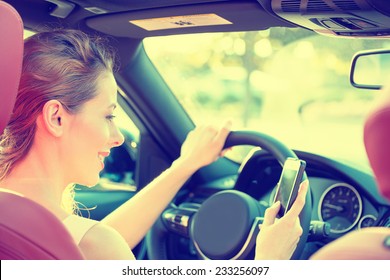 Young Beautiful Businesswoman Sending A Text Message Using Mobile Phone While Driving Car To Work. Risky, Reckless Driver Bad Habits. Traffic Safety Rule Violation Lack Of Attention Concept 