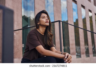 Young and beautiful businesswoman sitting with hands together looking away - Shutterstock ID 2167274811