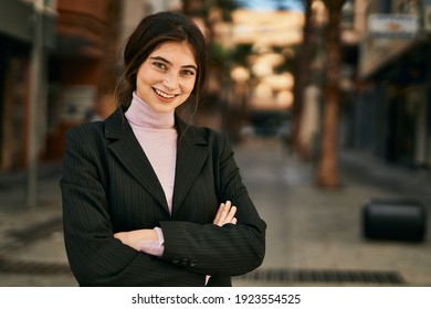 Young beautiful businesswoman smiling happy with arms crossed at the city.
