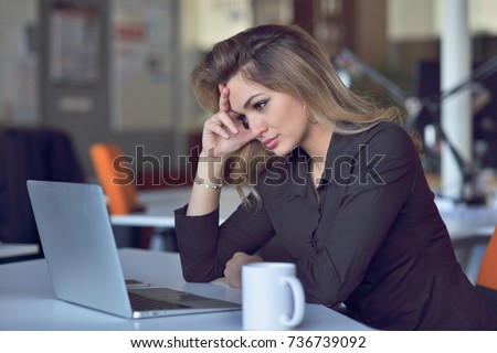 Young and beautiful businesswoman tired from work in the office.Woman holding her head.