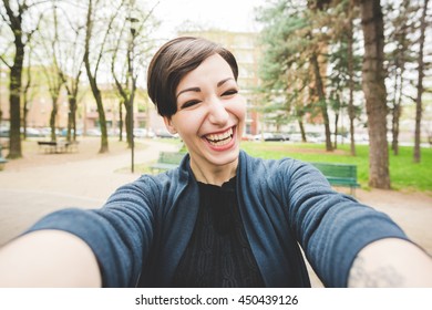 Young beautiful caucasian brown short hair woman happy taking selfie outdoor in the city - emancipation, happiness concept