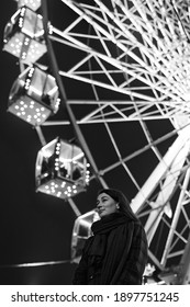 Young Beautiful Caucasian Brunette Woman Posing By Ferris Wheel At Night. Black And White Photos