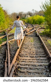 Young And Beautiful Caucasian Girl Walking On A Railway, Concept About Choosing A Direction In Life, The Decision To Follow A Certain Path To The Future.