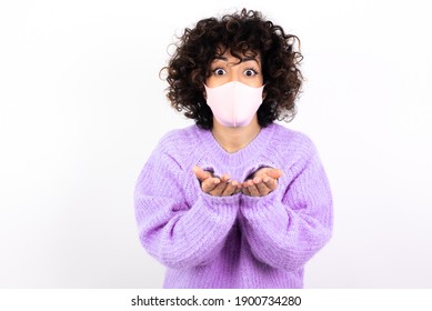 Young Beautiful Caucasian Woman Wearing Medical Mask Standing Against White Wall Sending Blow Kiss With Pout Lips And Holding Palms To Send Air Kiss.