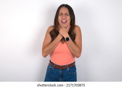 young beautiful caucasian woman wearing orange top over white background shouting suffocate because painful strangle. Health problem. Asphyxiate and suicide concept.