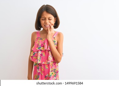 Young Beautiful Child Girl Wearing Pink Floral Dress Standing Over Isolated White Background Touching Mouth With Hand With Painful Expression Because Of Toothache Or Dental Illness On Teeth. Dentist