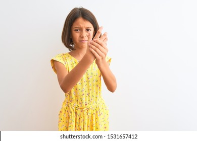 Young Beautiful Child Girl Wearing Yellow Floral Dress Standing Over Isolated White Background Suffering Pain On Hands And Fingers, Arthritis Inflammation