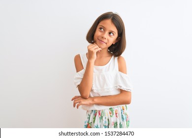 Young Beautiful Child Girl Wearing Casual Dress Standing Over Isolated White Background With Hand On Chin Thinking About Question, Pensive Expression. Smiling With Thoughtful Face. Doubt Concept.