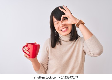 Young Beautiful Chinese Woman Drinking Red Cup Of Coffee Over Isolated White Background With Happy Face Smiling Doing Ok Sign With Hand On Eye Looking Through Fingers