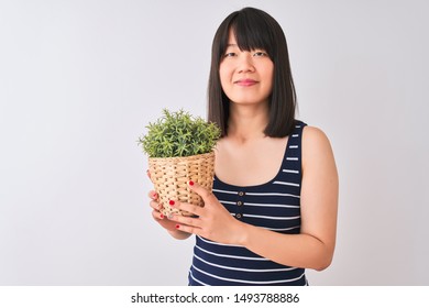 Young Beautiful Chinese Woman Holding Plant Pot Standing Over Isolated White Background With A Confident Expression On Smart Face Thinking Serious