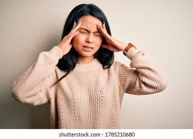Young beautiful chinese woman wearing casual sweater over isolated white background with hand on headache because stress. Suffering migraine.