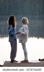 Young Beautiful Coach Helps Middle Aged Woman To Stand Barefoot On A Board With Nails. It Is Better If Someone Helps You Stand Up, Holding Hands. Board With Nails.