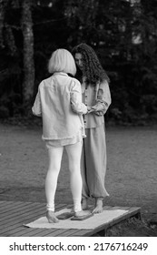 Young Beautiful Coach Helps Middle Aged Woman To Stand Barefoot On A Board With Nails. It Is Better If Someone Helps You Stand Up, Holding Hands. Board With Nails.