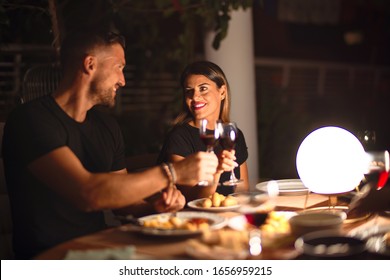 Young beautiful couple dinning on celebration toasting and smiling at terrace - Powered by Shutterstock