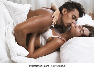 Young and beautiful couple in embrace lying on the bed