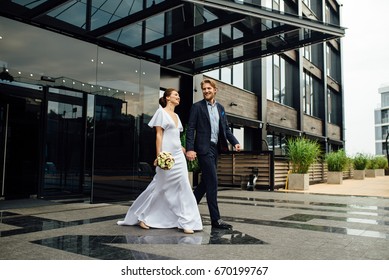young beautiful couple of just  married keep each other hands and go out from the hotel