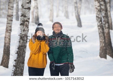 Young beautiful couple playing with snow in wintertime