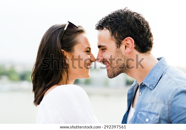 Young beautiful couple rubbing noses as a sign\
of love and about to kiss each\
other