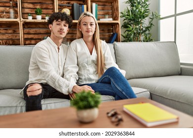 Young Beautiful Couple Sitting On The Sofa At Home Thinking Attitude And Sober Expression Looking Self Confident 