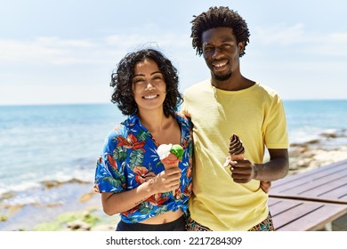 Young Beautiful Couple Smiling Happy Eating Ice Cream At The Beach.