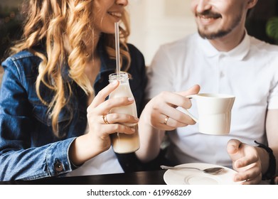 Young Beautiful Curly Blonde Bride Couple In Love With Hipsters In A Cafe With A Milkshake With A Straw In A Denim Jacket